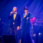 Joël Legendre et Marie Carmen dans un tableau du spectacle Noël une tradition en chanson 2023. Crédit : Jean-Charles Labarre / Courtoisie Production